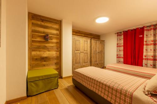 1 dormitorio con 2 camas y cortina roja en Maison La Louche - Courmayeur, en Courmayeur