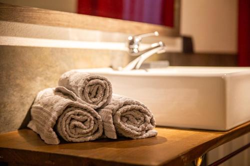 a pile of towels sitting on a counter next to a sink at Maison La Louche - Courmayeur in Courmayeur