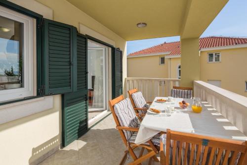 a balcony with a table and chairs on a balcony at Apartments Leon in Podstrana
