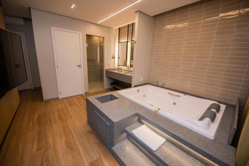 a large bathroom with a bath tub in a room at Origens Hotel in São Luís Gonzaga