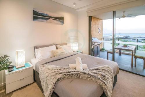 a bedroom with a large bed and a balcony at ZEN BY THE OCEAN - 1-BR Executive Biz Retreat in Darwin