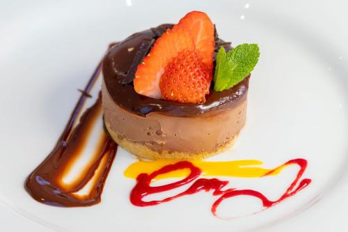 a chocolate dessert with a strawberry on a white plate at Saints Bay Hotel in St Martin Guernsey