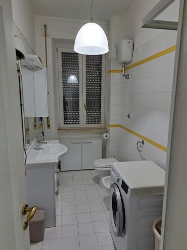 a white bathroom with a sink and a washing machine at Welcome home in Terni