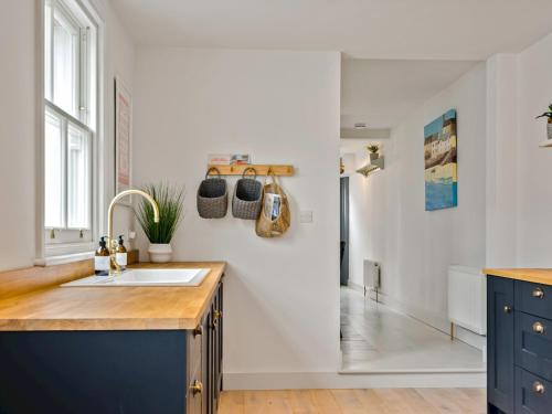 uma cozinha com um lavatório e um armário azul em Limewood Newly Renovated High End Home by the Sea em Whitstable