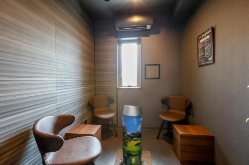 a waiting room with three chairs and a window at Dormy Inn Okayama Natural Hot Spring in Okayama