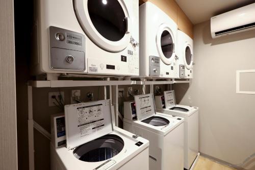 a room with four washers and dryers on display at Dormy Inn Okayama Natural Hot Spring in Okayama