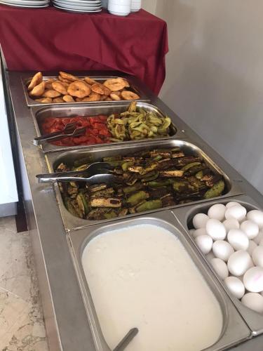 ein Buffet mit mehreren Tabletts mit Speisen und Eiern in der Unterkunft Tal Beach Hotel in Beldibi