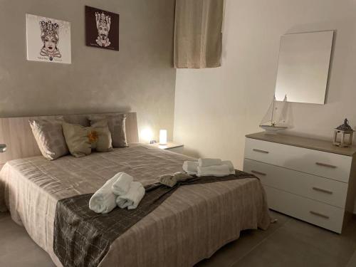a bedroom with a bed with towels on it at La Pietra di Giada in Siracusa
