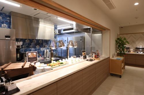 a kitchen with a counter with food on it at Dormy Inn Okayama Natural Hot Spring in Okayama