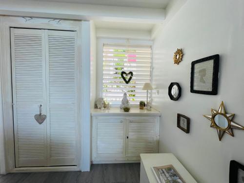 a room with a window with a white door and a table at Blue Lagoon, cottage les pieds dans l eau in Terre-de-Haut