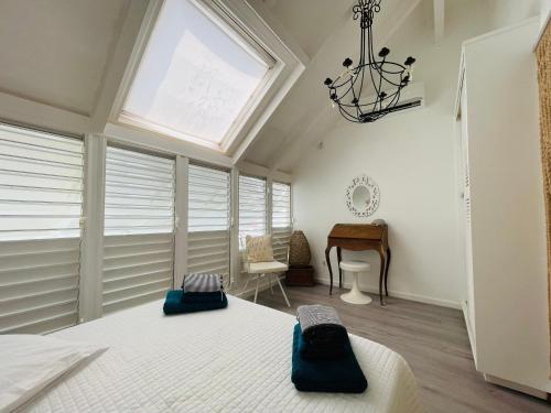 a bedroom with a bed and a window and a desk at Blue Lagoon, cottage les pieds dans l eau in Terre-de-Haut