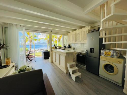 a large kitchen with a view of the ocean at Blue Lagoon, cottage les pieds dans l eau in Terre-de-Haut