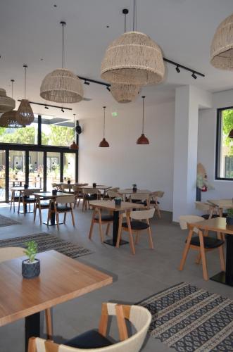 a restaurant with wooden tables and chairs and windows at Cook's Club Ialysos Rhodes in Ialyssos