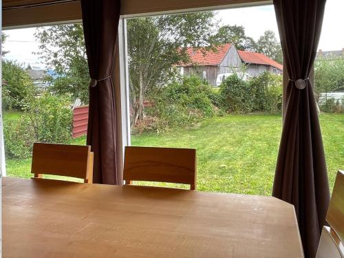 una mesa y sillas frente a una gran ventana en Ferienhaus Stefanie, en Bernbeuren