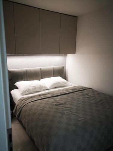 ein Schlafzimmer mit einem Bett mit weißen Kissen in der Unterkunft Apartman Hobit in Opatija