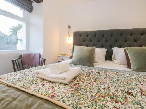 a bed with two towels on top of it at Turn Cottage in Ulverston