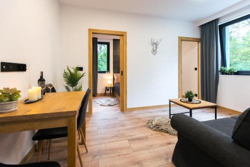 - un salon avec une table en bois et un canapé dans l'établissement Jaśmin Apartamenty, à Krynica-Zdrój