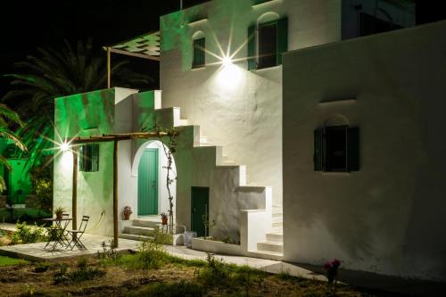 a white house with a green door and stairs at ANCIENT MEROPIA - Les jardins des muses in Apollonia