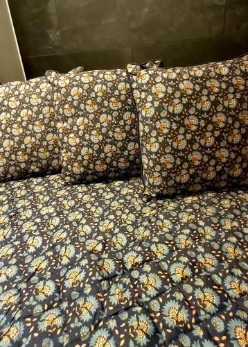 a bed with a floral comforter and two pillows at Jaśmin Apartamenty in Krynica Zdrój