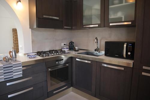 a kitchen with a sink and a stove and a microwave at Antura in Pantelleria