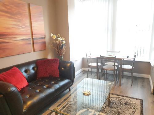 a living room with a leather couch and a table at The Savile, Luxury Apartment Leeds - Your Next Stay in Leeds