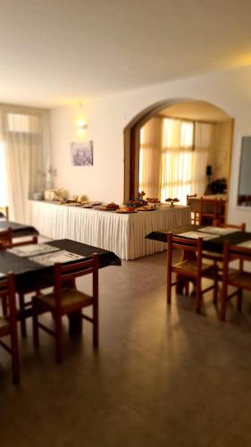 a room with tables and a bed in the background at PEDA Hotel Ristorante Pizzeria in Colletorto
