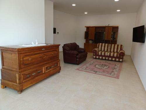 sala de estar con cómoda y silla en Il Colle Casa Vacanze, en Macchiagodena