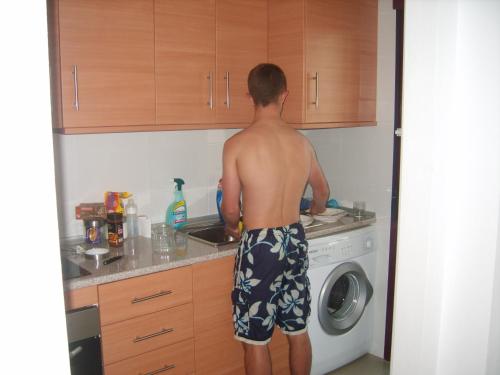 a man standing in the kitchen preparing food at Apartment C6 Phase 4 Mojon Hills, Isla Plana, CERTIFICATE OF EXCELLENCE in Isla Plana