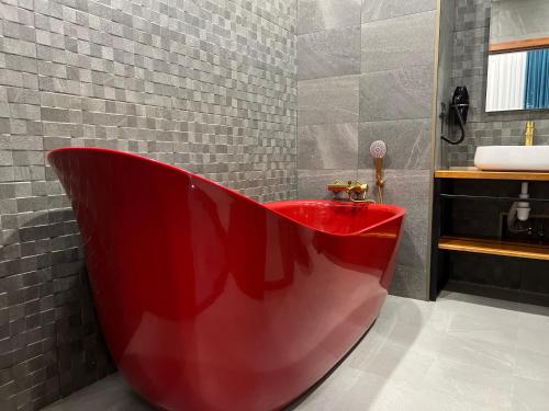 baño con bañera roja y lavamanos en TownHouse Tbilisi Boutique Hotel, en Tiflis
