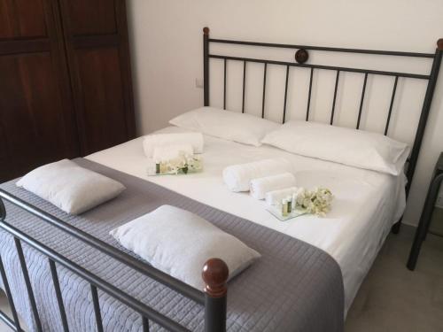 a bed with white towels and flowers on it at Antura in Pantelleria