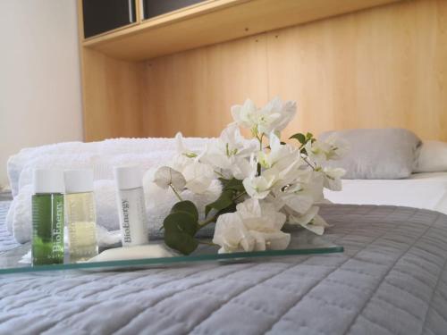 a tray with white flowers on top of a bed at Antura in Pantelleria