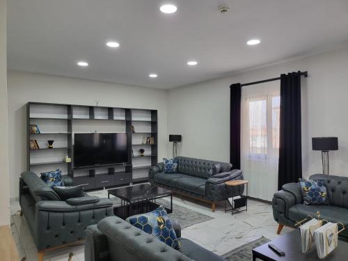 a living room with couches and a flat screen tv at MALATYA NORVIA HOTEL in Malatya