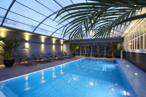 a swimming pool in a building with a glass ceiling at PortoBay Serra Golf in Santo da Serra