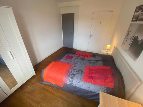 a small bedroom with a bed with a red blanket at Fabuleux T3 climatisé de 85 m2, situé au calme avec grand parking gratuit privé ,Fibre wifi in Saint-Gaudens