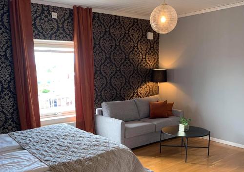 a bedroom with a bed and a couch and a window at Hotell Ronja in Vimmerby