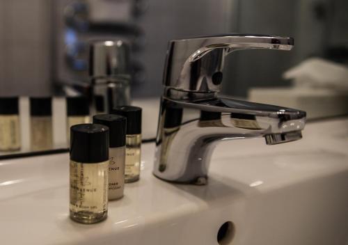 um lavatório de casa de banho com duas garrafas de cosméticos em Hotell Ronja em Vimmerby