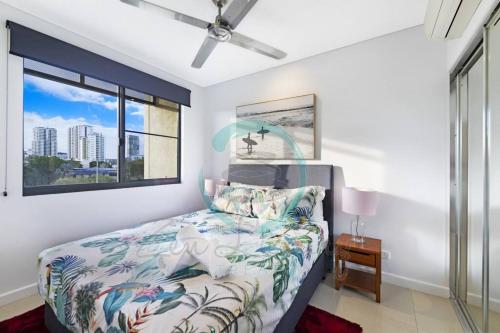 een slaapkamer met een bed en een raam bij ZEN AT ARKABA 3BR Luxury Waterfront Apt Pool + BBQ in Darwin