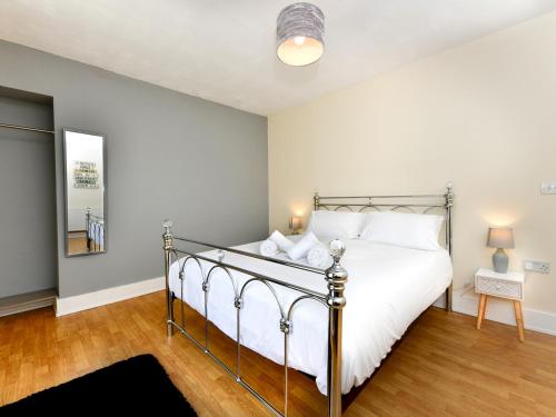 um quarto com uma cama grande e lençóis brancos em Pass the Keys Central Swansea townhouse 4B Mins from everything em Swansea
