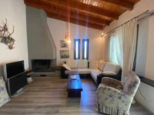 sala de estar con sofá y TV en Country house by the sea !!!, en Karavómilos