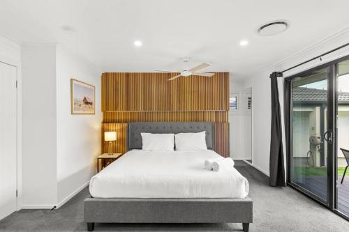 una camera con un letto bianco e una finestra di Ultra Modern & Relaxing Inner City 4bed House - with a Private Pool - 10mins walk to Beach a Gold Coast