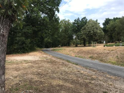 une route sinueuse dans un parc arboré dans l'établissement Chalet lumineux au cœur du Périgord Noir, à La Machome