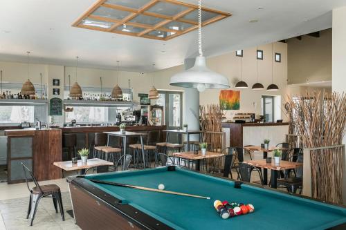 a pool table in a room with tables and chairs at ASTRA Village Resort in Svoronata