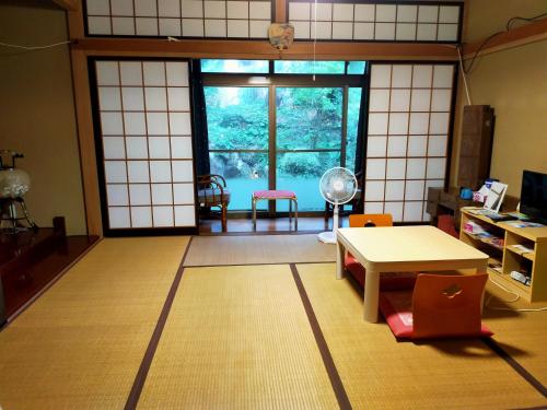 阪井市的住宿－越前ゲストハウスTAMADA，客房设有桌椅和窗户。