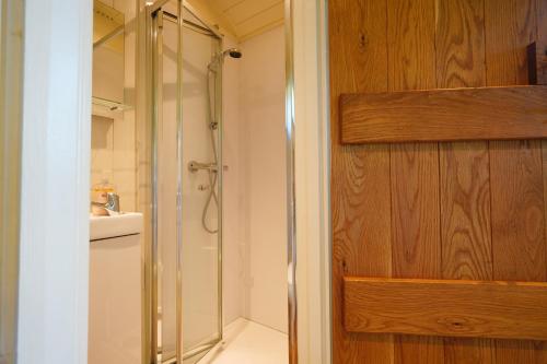 een badkamer met een douche en een glazen deur bij Lavender Retreat with Private Hot Tub in Upper Hulme