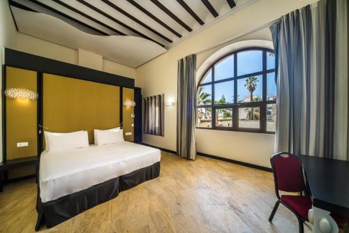 - une chambre avec un lit et une grande fenêtre dans l'établissement Hotel Palacio Marqués de Arizón, à Sanlúcar de Barrameda