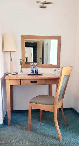 a wooden desk with a chair and a mirror at Hotel Zajazd Kultury, dawniej Pocztowy in Zielona Góra
