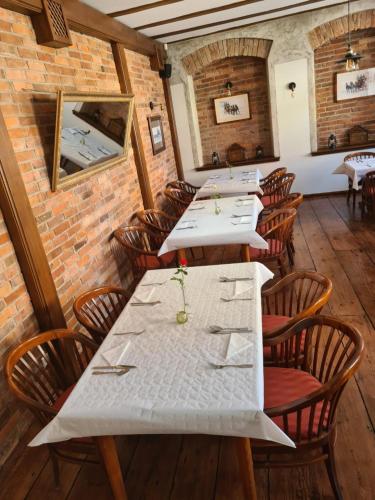 a dining room with tables and chairs and a brick wall at Hotel Zajazd Kultury, dawniej Pocztowy in Zielona Góra