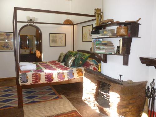 a living room with a bed and a fireplace at Samira's Birds & Butterflies Park-Spashram Ganga Beach Retreat in Rishīkesh