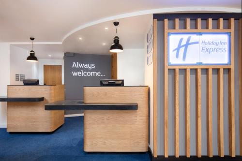 an office with reception desks and a welcome sign at Holiday Inn Express Strathclyde Park M74, Jct 5 by IHG in Motherwell