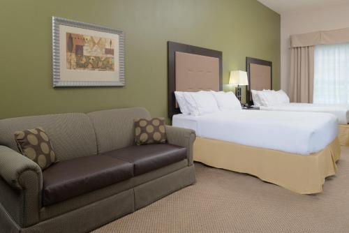 a hotel room with two beds and a couch at Holiday Inn Express Hotel & Suites North Sequim by IHG in Sequim